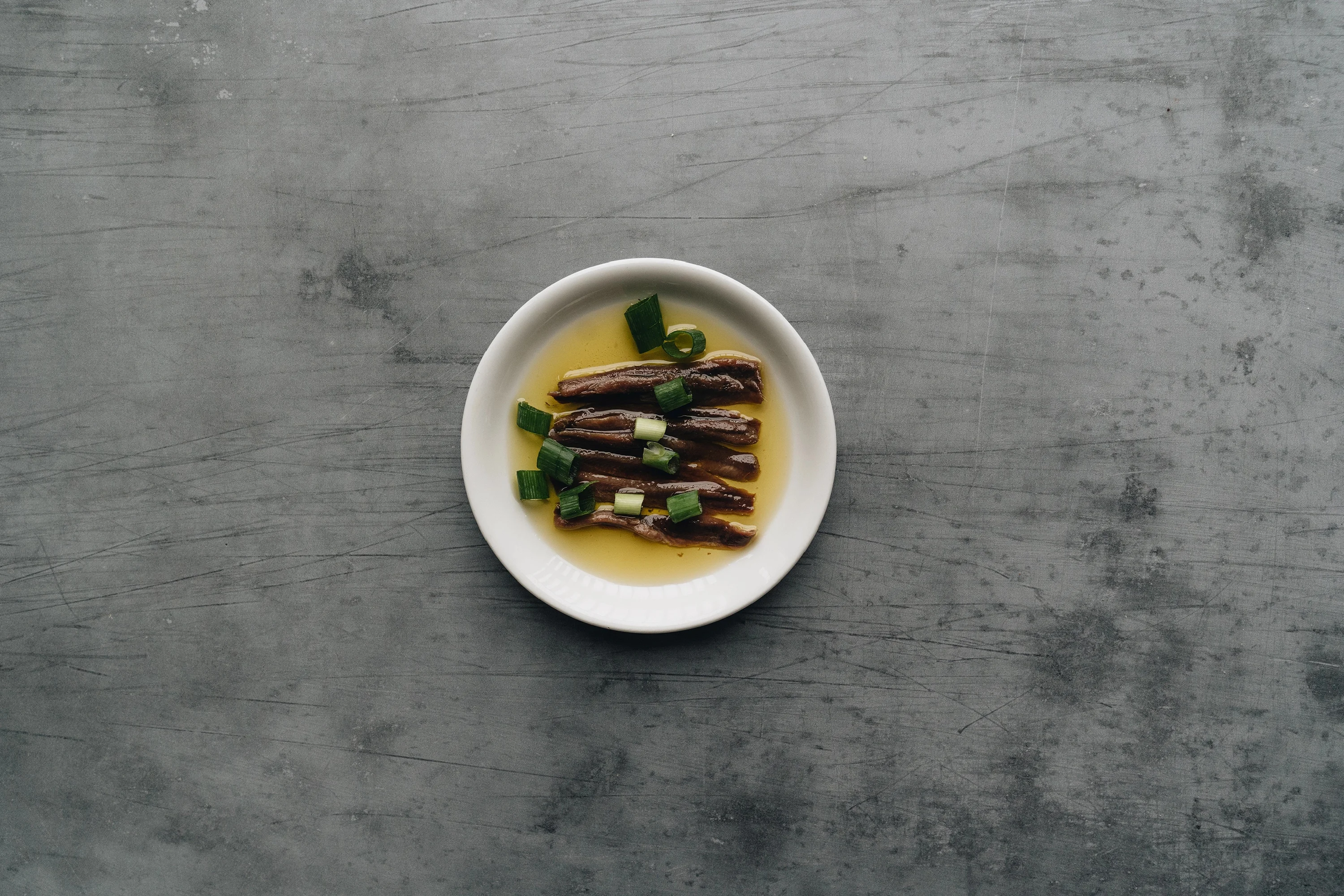 tinned fish soaking in olive oil on a small plate